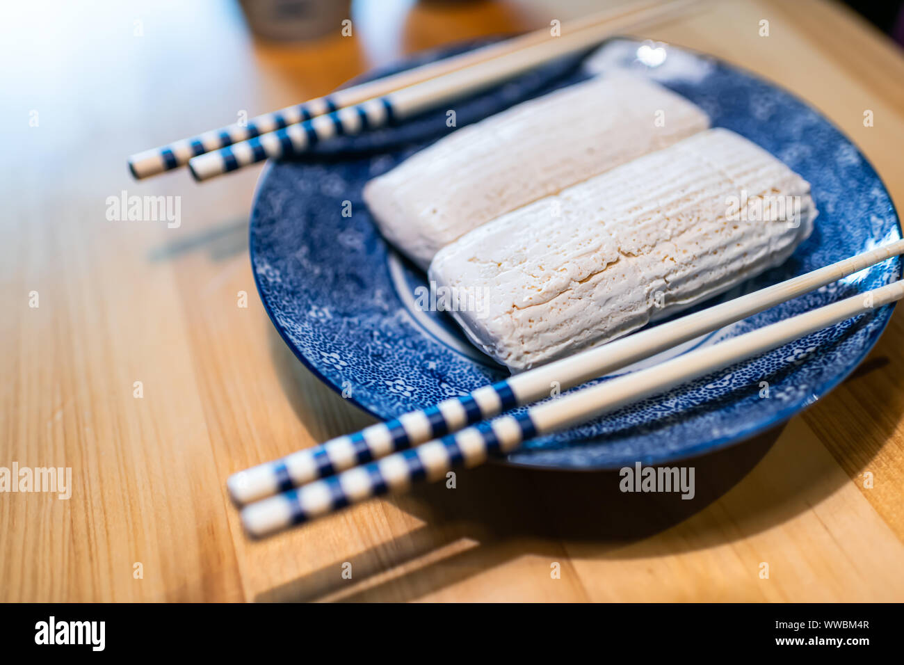 Komo traditionnels japonais tofu ou aliments dofu avec des baguettes sur verre plaque bleue sur la table en bois cuisine produit Takayama Hida ours dans la préfecture de Gifu Banque D'Images