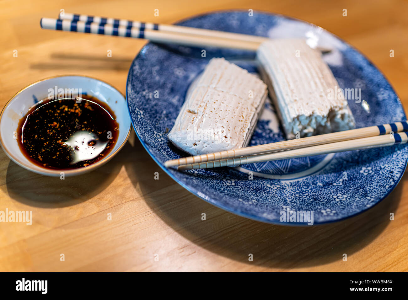 Vue latérale du traditionnel japonais tofu komo dofu, baguettes et alimentaire de la sauce soja sur la plaque sur une table en bois cuisine à Takayama, dans la préfecture de Gifu Hida Banque D'Images