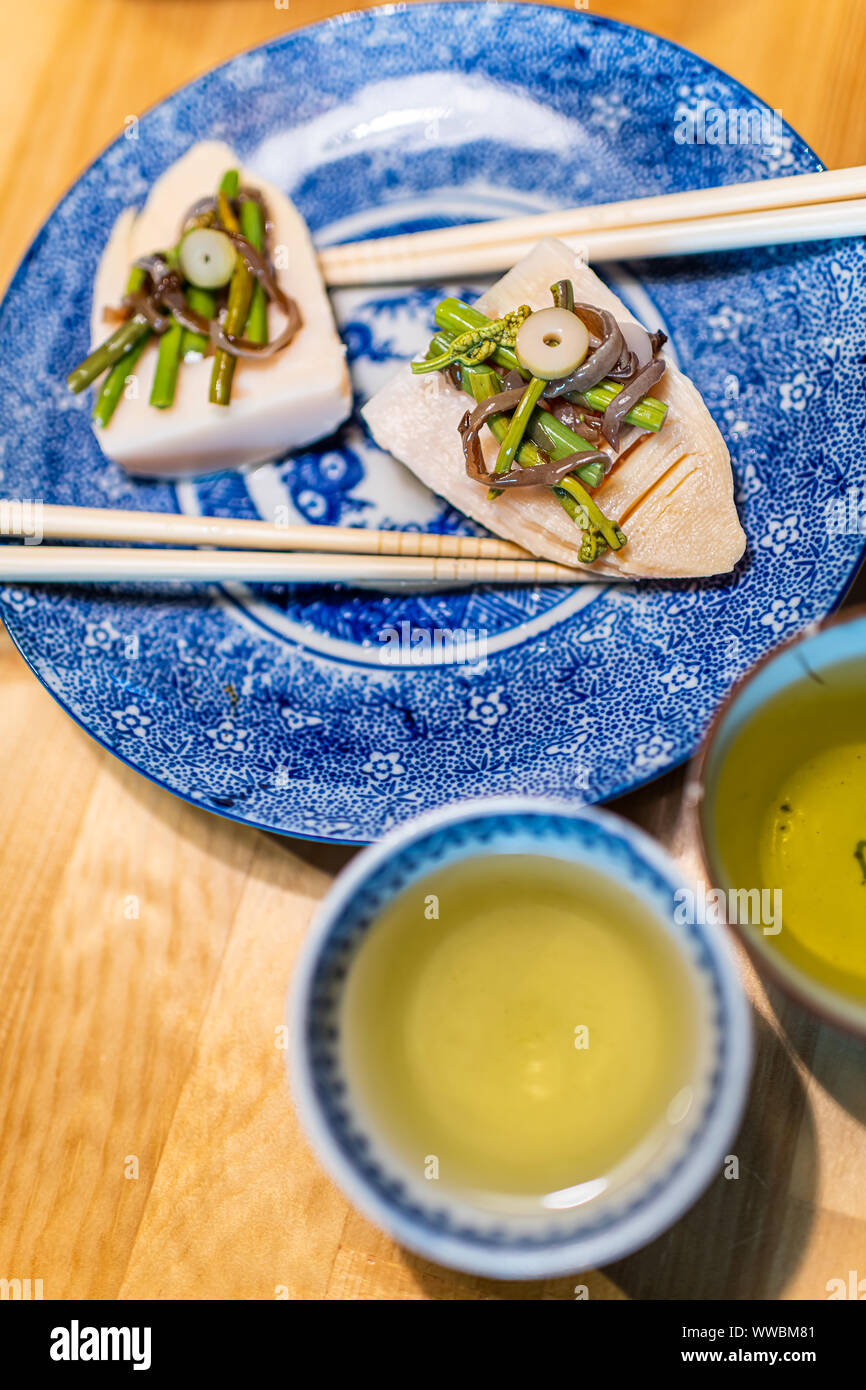 Restaurant traditionnel japonais sur la plaque de table en bois avec des légumes de printemps takenoko de pousses de bambou, sansai d'herbes sauvages avec des baguettes, sencha Banque D'Images