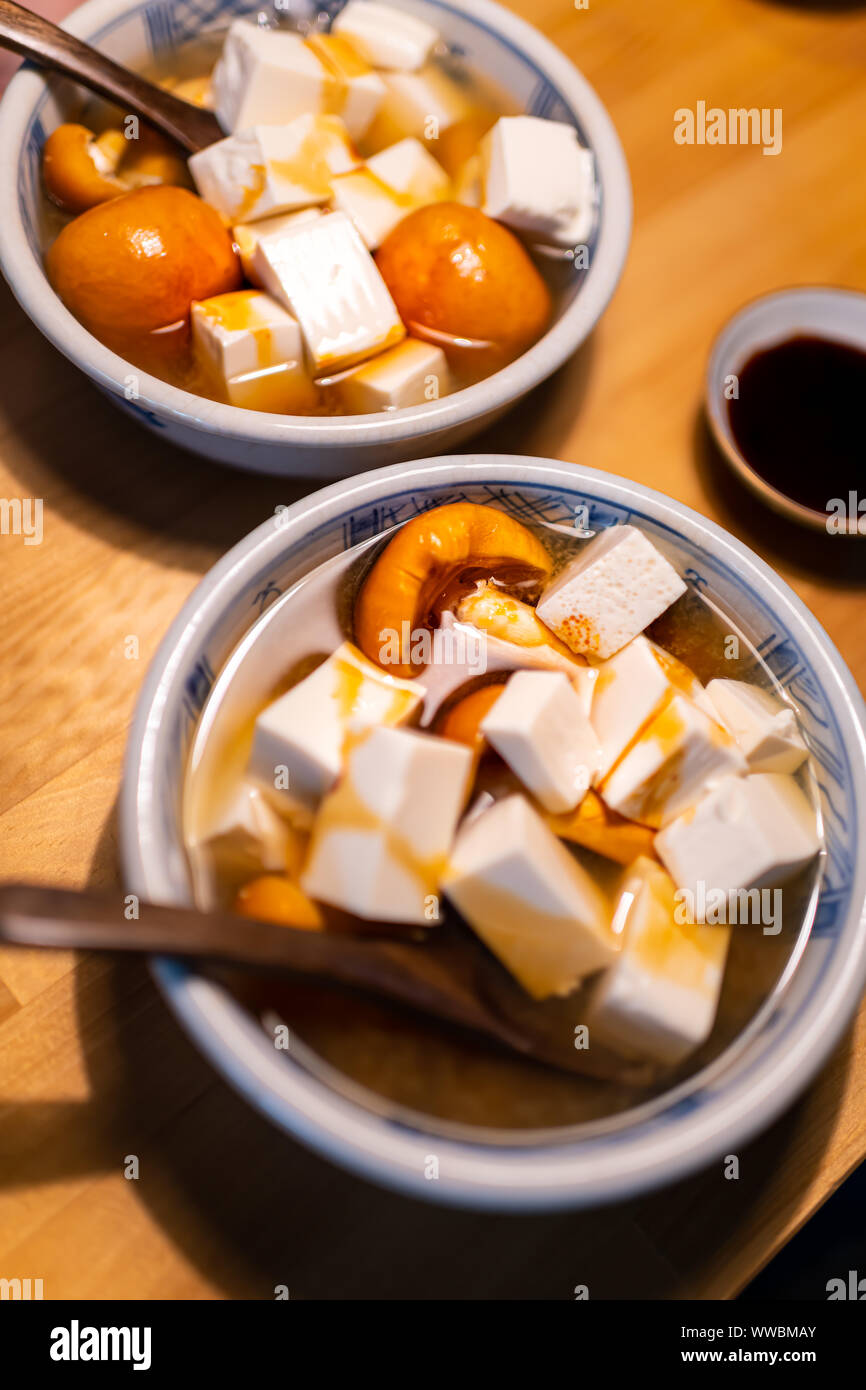 Bol en céramique traditionnelle japonaise Cuisine restaurant sur table en bois avec la soupe aux légumes de printemps miel plat de champignons, les cubes de tofu et sauce soja Banque D'Images