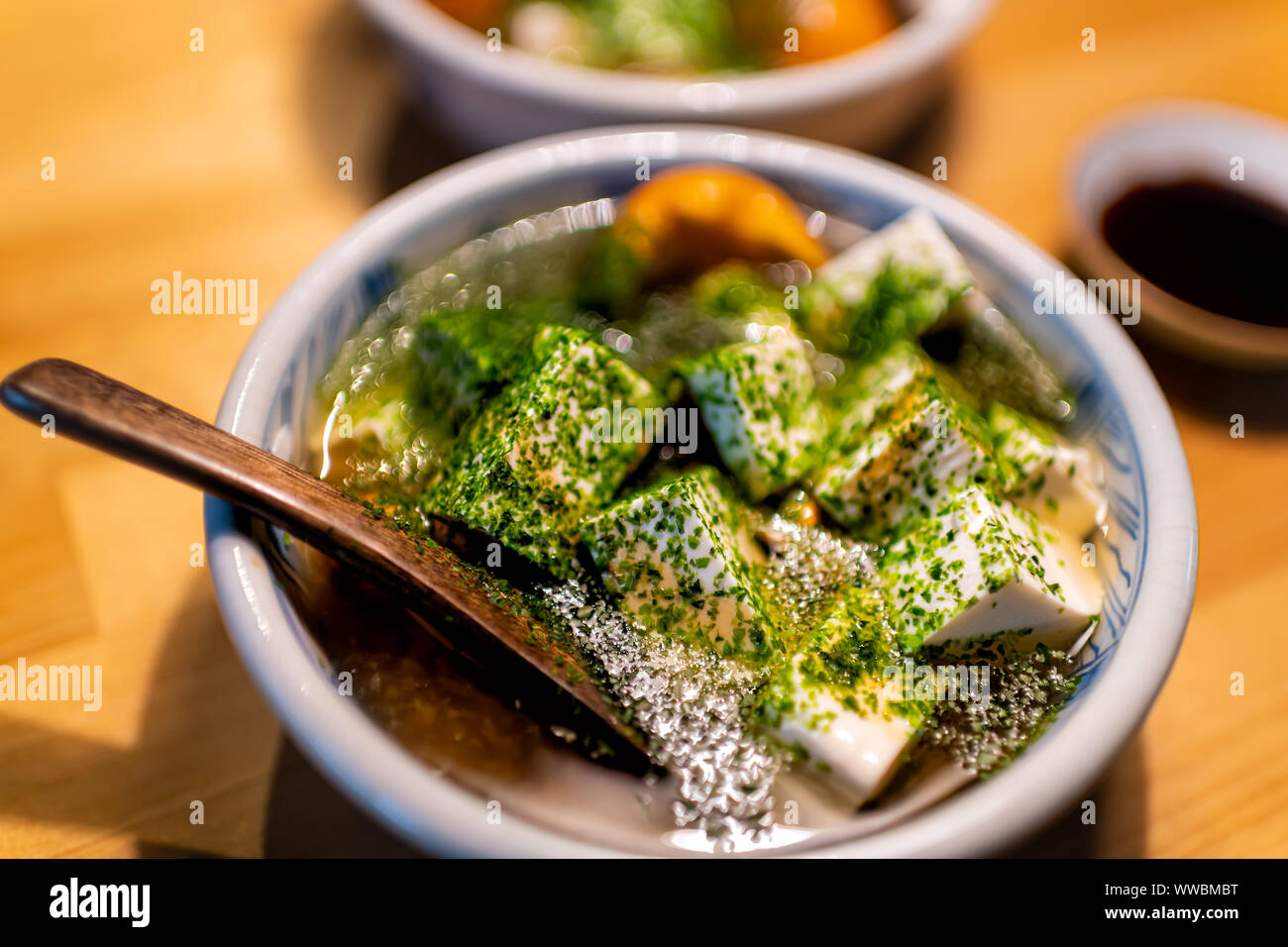 Bol japonais traditionnel cuillère en bois sur la table de cuisine de restaurant avec la soupe aux légumes de printemps miel plat de champignons, les cubes de tofu dans la sauce de soja et aon Banque D'Images
