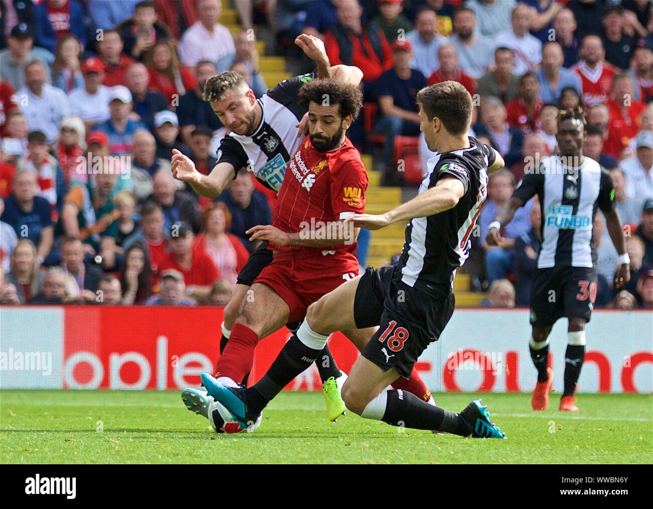 Liverpool, Royaume-Uni. 14Th Sep 2019. Mohamed Salah de Liverpool (2L) est abordé par Newcastle United's Paul Dummett (1ère L) et Federico Fernandez (2e R) au cours de l'English Premier League match entre Liverpool et Newcastle United à Anfield à Liverpool, Angleterre le 14 septembre 2019. Liverpool a gagné 3-1. Source : Xinhua/Alamy Live News Banque D'Images