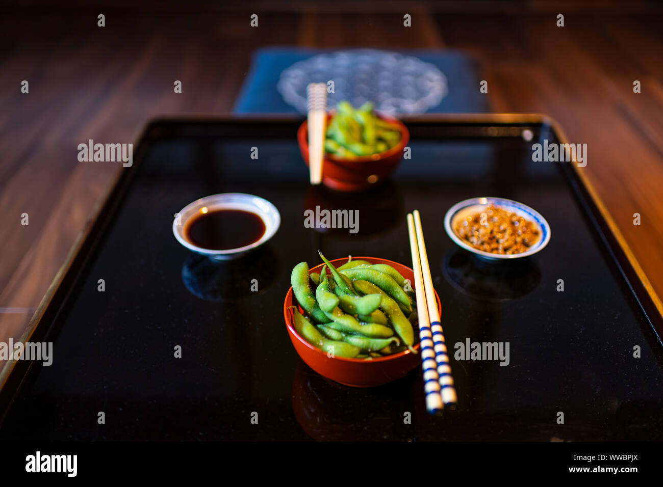 Bol plaque traditionnelle japonaise au restaurant ou kaiseki ryokan avec légumes de sel bouillis, edamame et sauce soya Natto sur plaque avec chopstic Banque D'Images