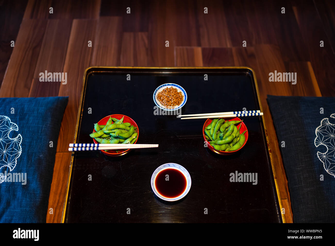 Télévision Vue de dessus en japonais traditionnels kaiseki ryokan avec légumes de sel bouillis, natto edamame et sauce de soja sur la plaque par baguettes sur disque Banque D'Images