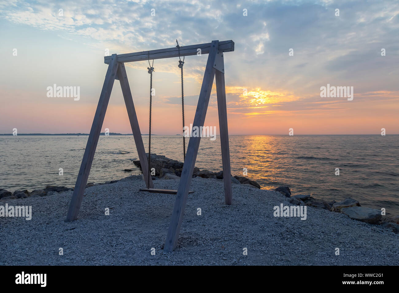 Chaise en bois près de la mer, sur le coucher du soleil d'été Banque D'Images