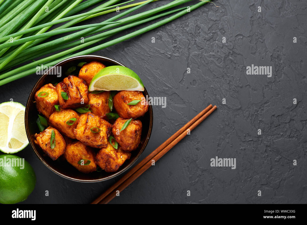 Paneer Mandchou ou Paneer 65 Bol en béton noir à l'arrière-plan. Paneer Mandchou est Indian cuisine Chinoise plat d panner le fromage, les tomates, le Banque D'Images