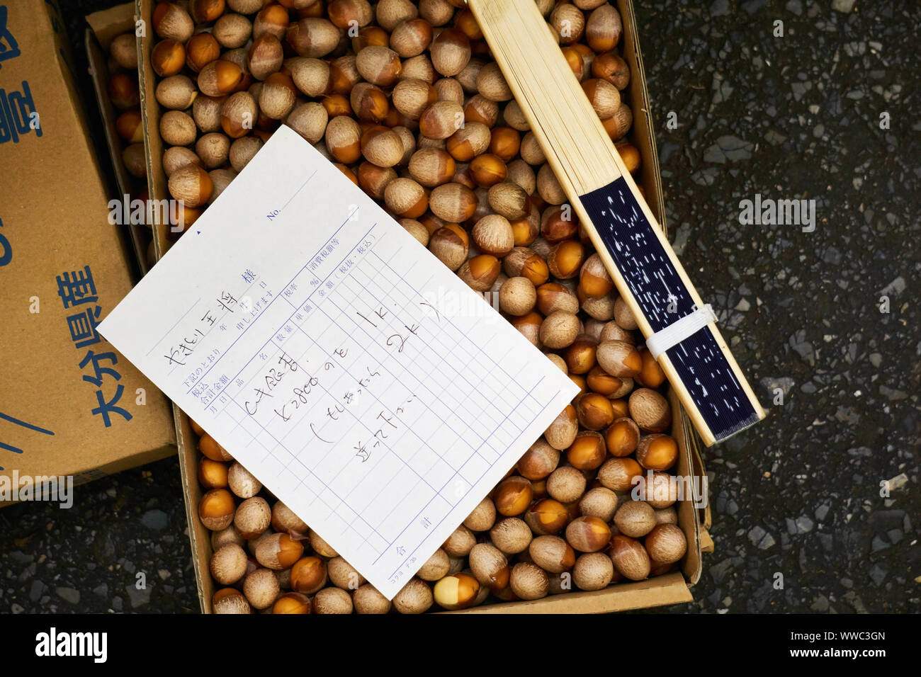 Une boîte en carton remplie de ginnan (noix de ginkgo) et un bon de commande demandant un ou deux kilogrammes de noix à un grossiste du marché de Tsukiji. Banque D'Images