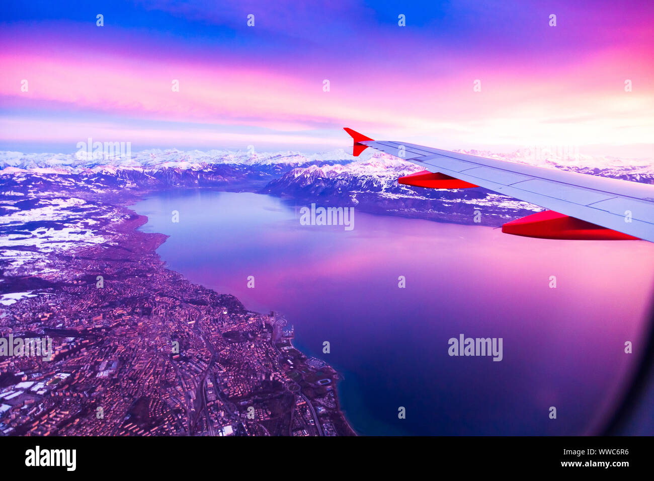 Vue imprenable depuis la fenêtre de l'avion pendant le coucher du soleil sur le lac de Genève, Suisse Banque D'Images