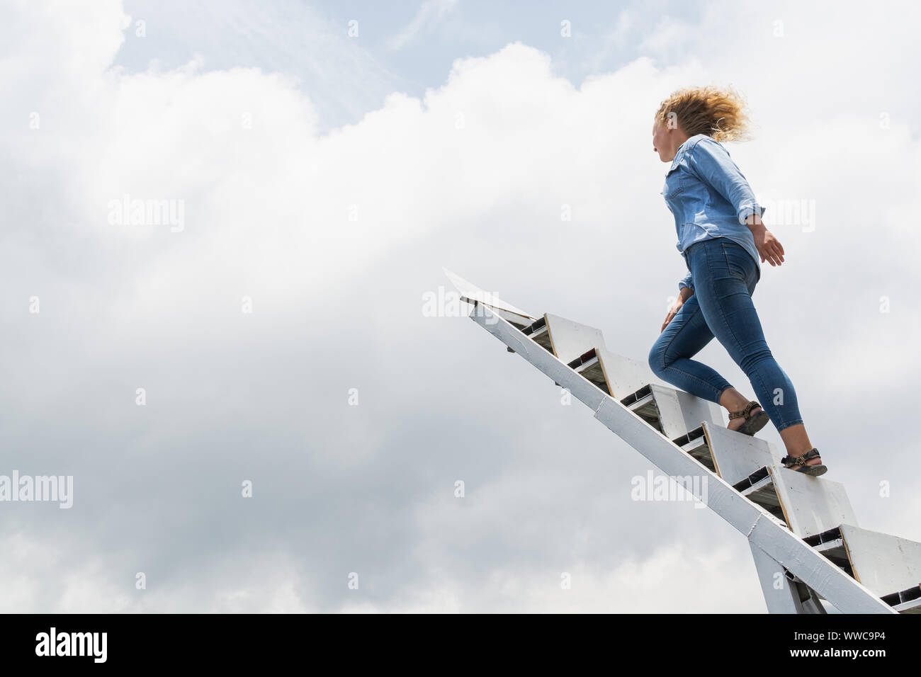 Libre en montant les escaliers vers le ciel avec des nuages sur l'arrière-plan. Banque D'Images