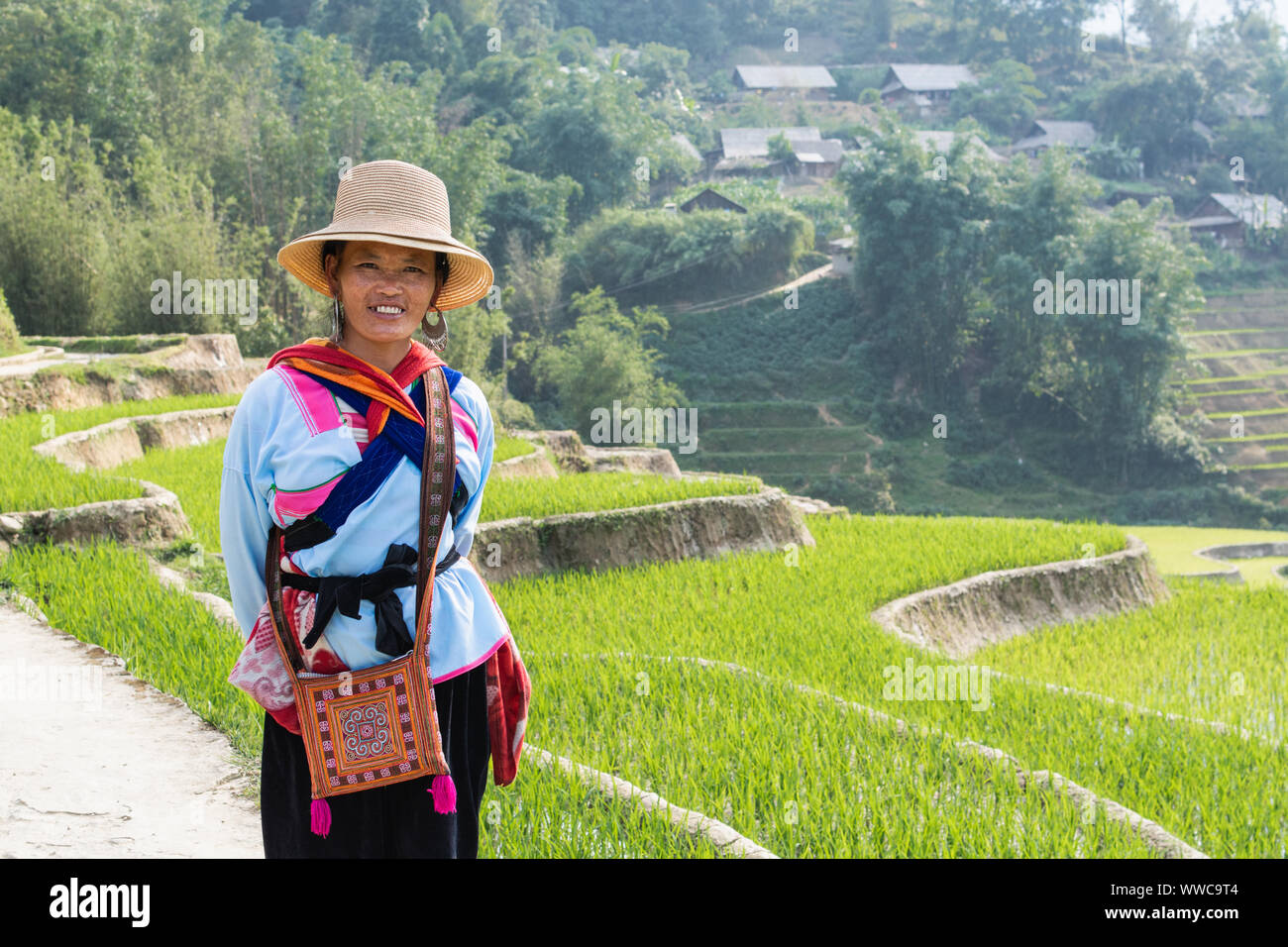 Sapa, Vietnam - Mai 2019 : femme de l'ethnie hmong en costume traditionnel marche à côté de la terrasse de riz dans la province de Lao Cai Banque D'Images