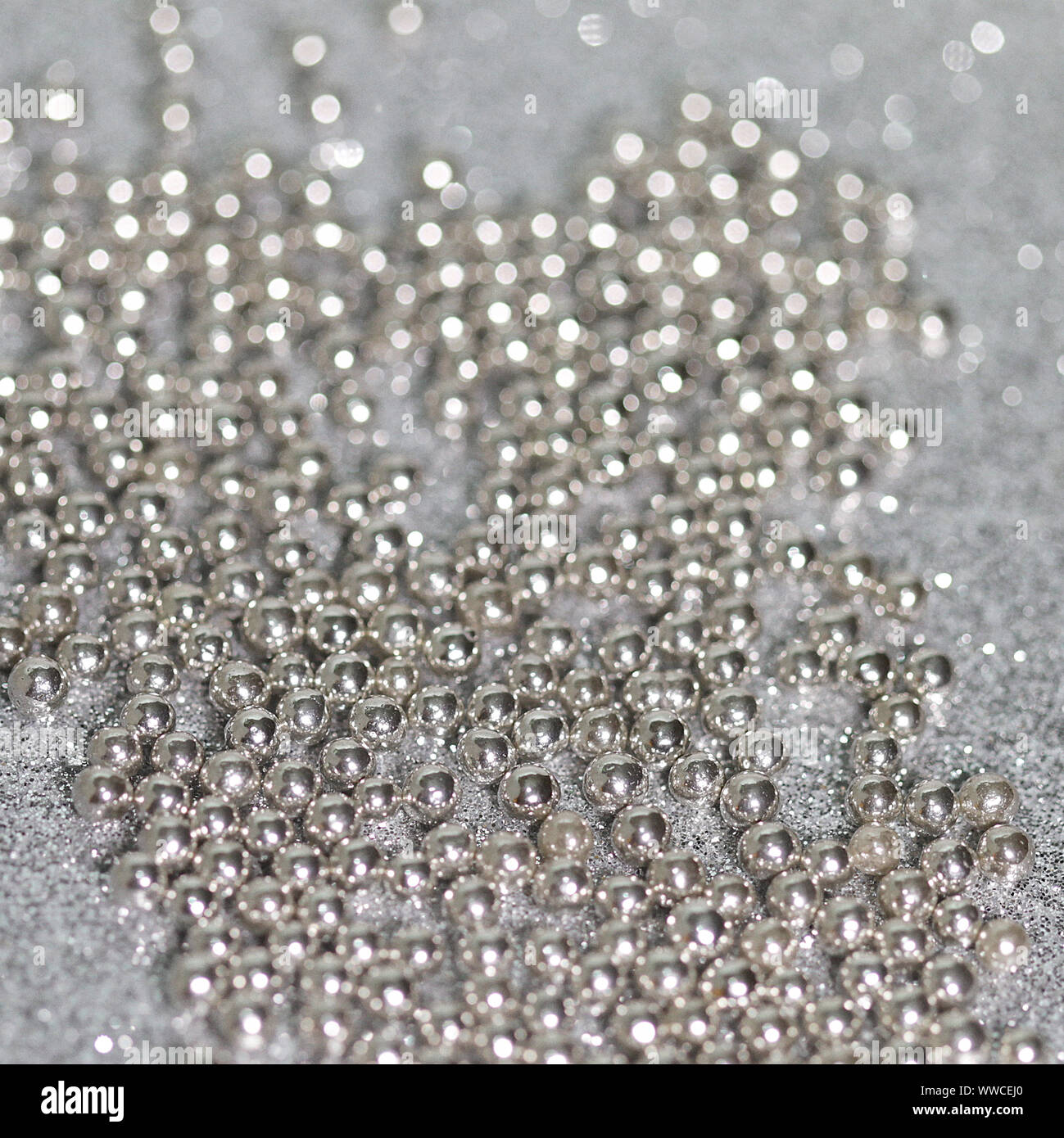 Saupoudrer argent dragées. Extreme Close Up. Petites boules de confiserie d'argent enrobées de sucre pour la décoration. L'accent dans le centre. Arrière-plan flou. Banque D'Images