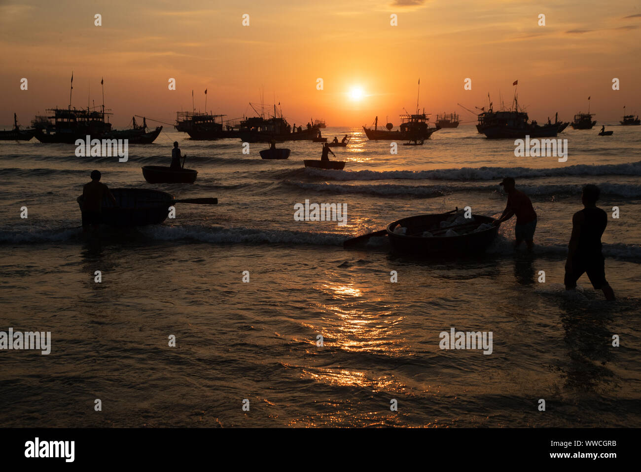 Amener les pêcheurs à terre prises dans panier de bateaux plus gros bateaux Cam Ha Hoi An Vietnam Banque D'Images