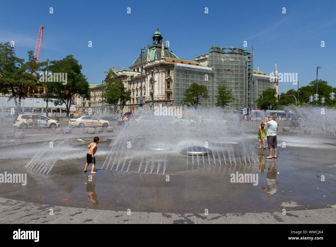 Enfants jouant dans la fontaine d'eau dans la Karlsplatz, Munich, Bavière, Allemagne. Banque D'Images