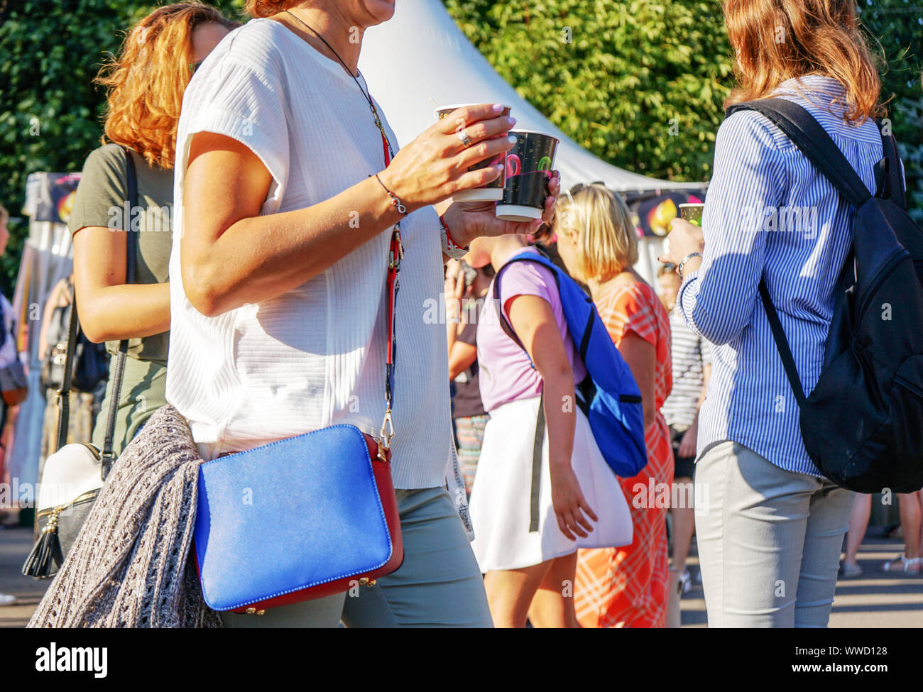 Une femme en blouse blanche et avec un élégant sac à main bleu dans une grande ville. Banque D'Images