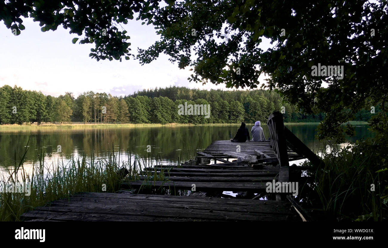 Couple assis sur une jetée en bois, Moletai, Lituanie Banque D'Images