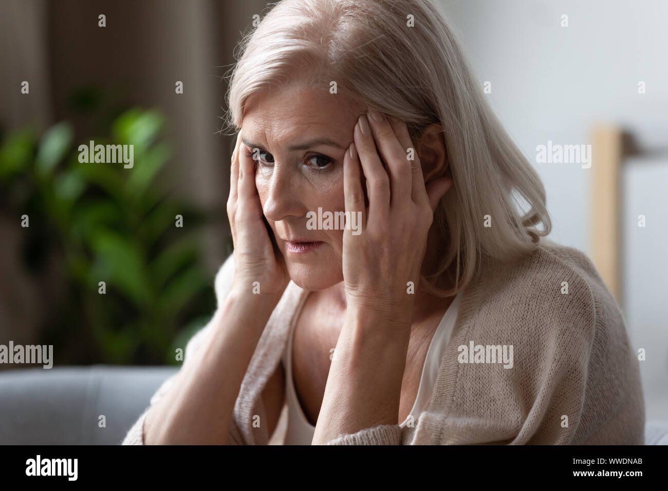 Femme plus âgée bouleversée de toucher des temples, se sentir mal, de troubles mentaux Banque D'Images