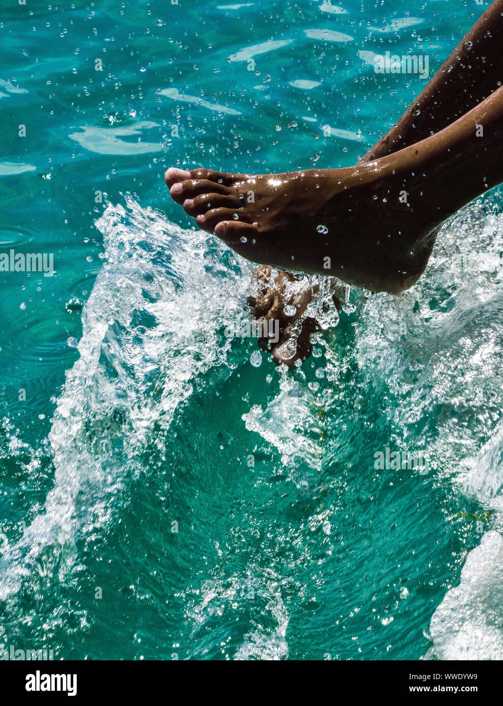 Pieds jouant sur l'eau de mer Banque D'Images