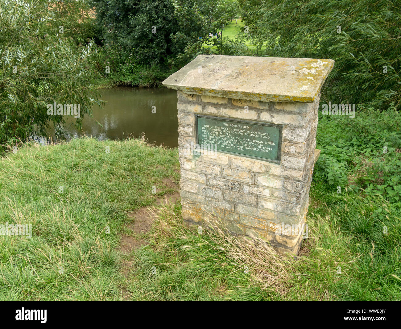 Socle en pierre avec plaque marquant l'emplacement de l'ancienne grande route du Nord ford / traversée de la rivière Welland, Stamford, Lincolnshire, Angleterre, RU Banque D'Images
