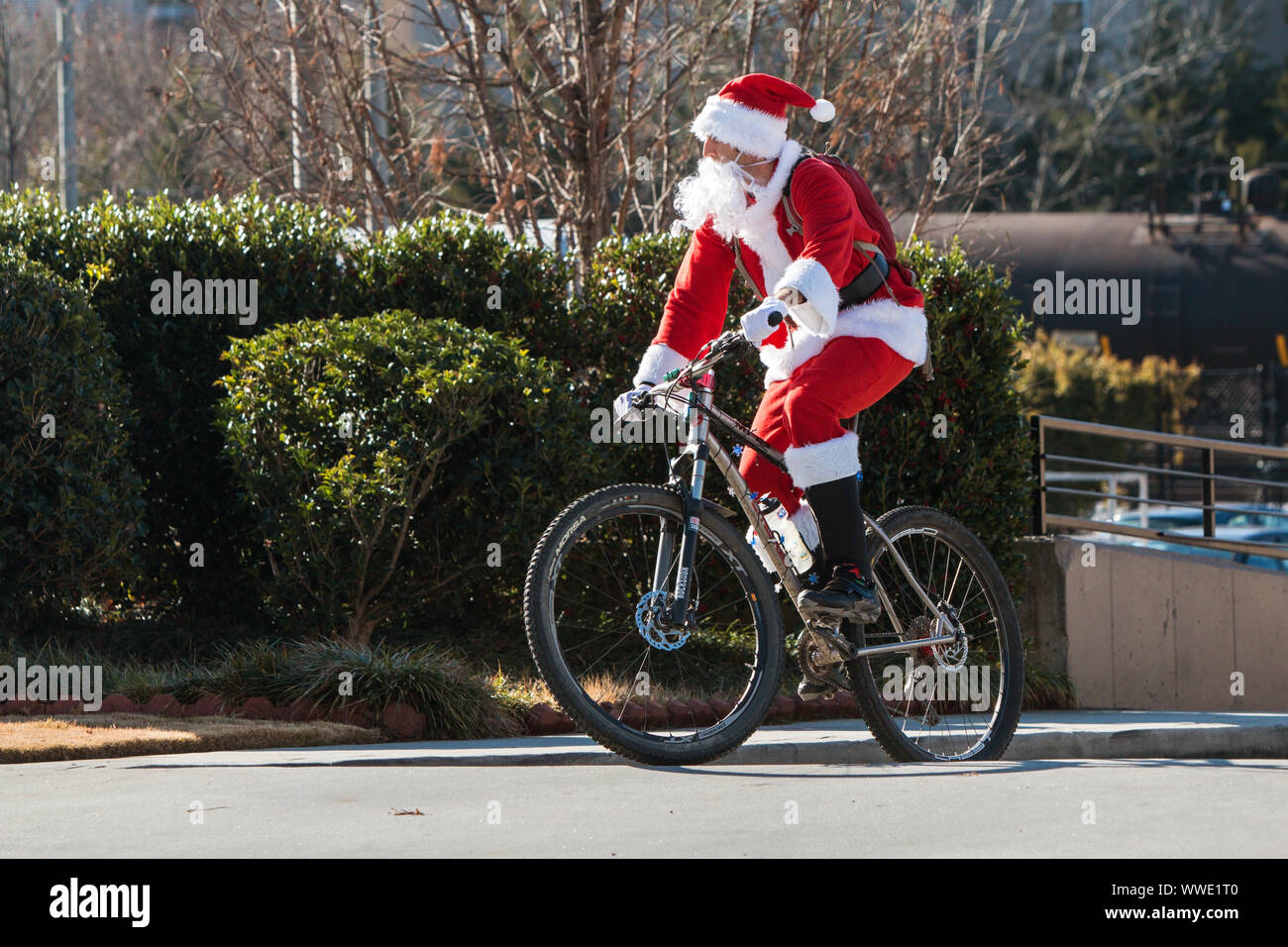 Un homme portant un costume de Père Noël monte un vélo en haut d'une colline, alors qu'il se prépare à monter dans la Tour Delanta en vtt sur Décembre 22, 2018 à Atlanta, GA. Banque D'Images