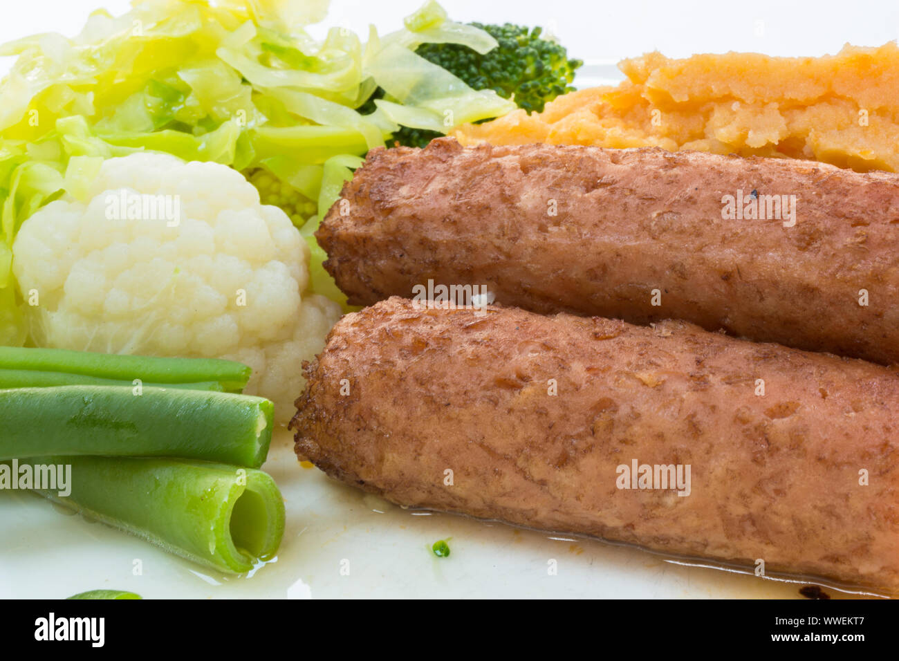 De viande plats végétariens et végétaliens les saucisses. Sur une assiette de légumes - haricots verts, chou-fleur, chou, brocoli et pommes de terre en purée. Banque D'Images