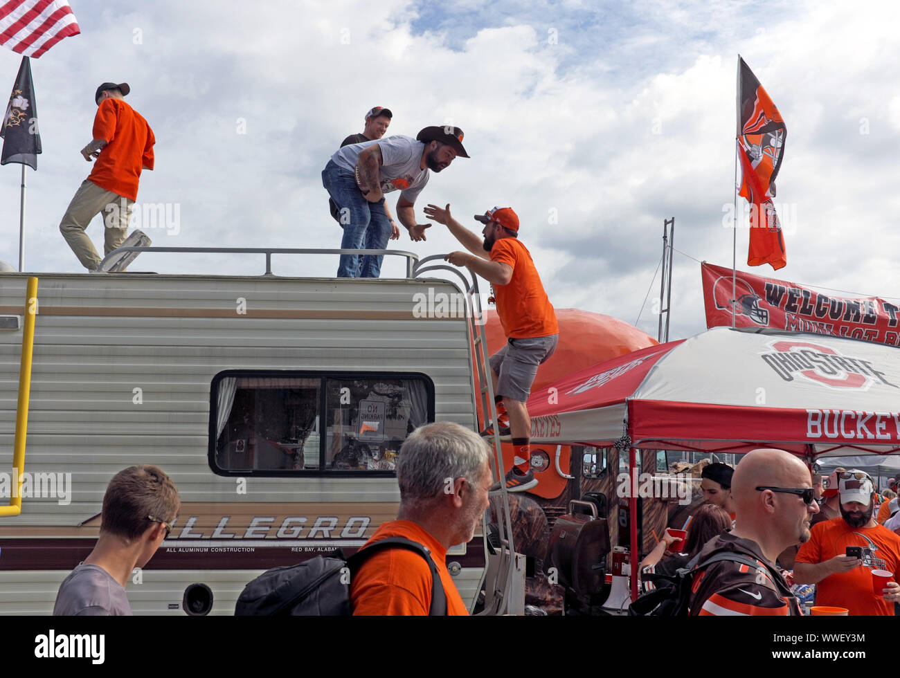 Un groupe De Fans de Cleveland Browns grimpent sur un RV pendant les festivités de tailleurs dans le Lot de Mui de Cleveland, Ohio, États-Unis avant un jeu à la maison. Banque D'Images