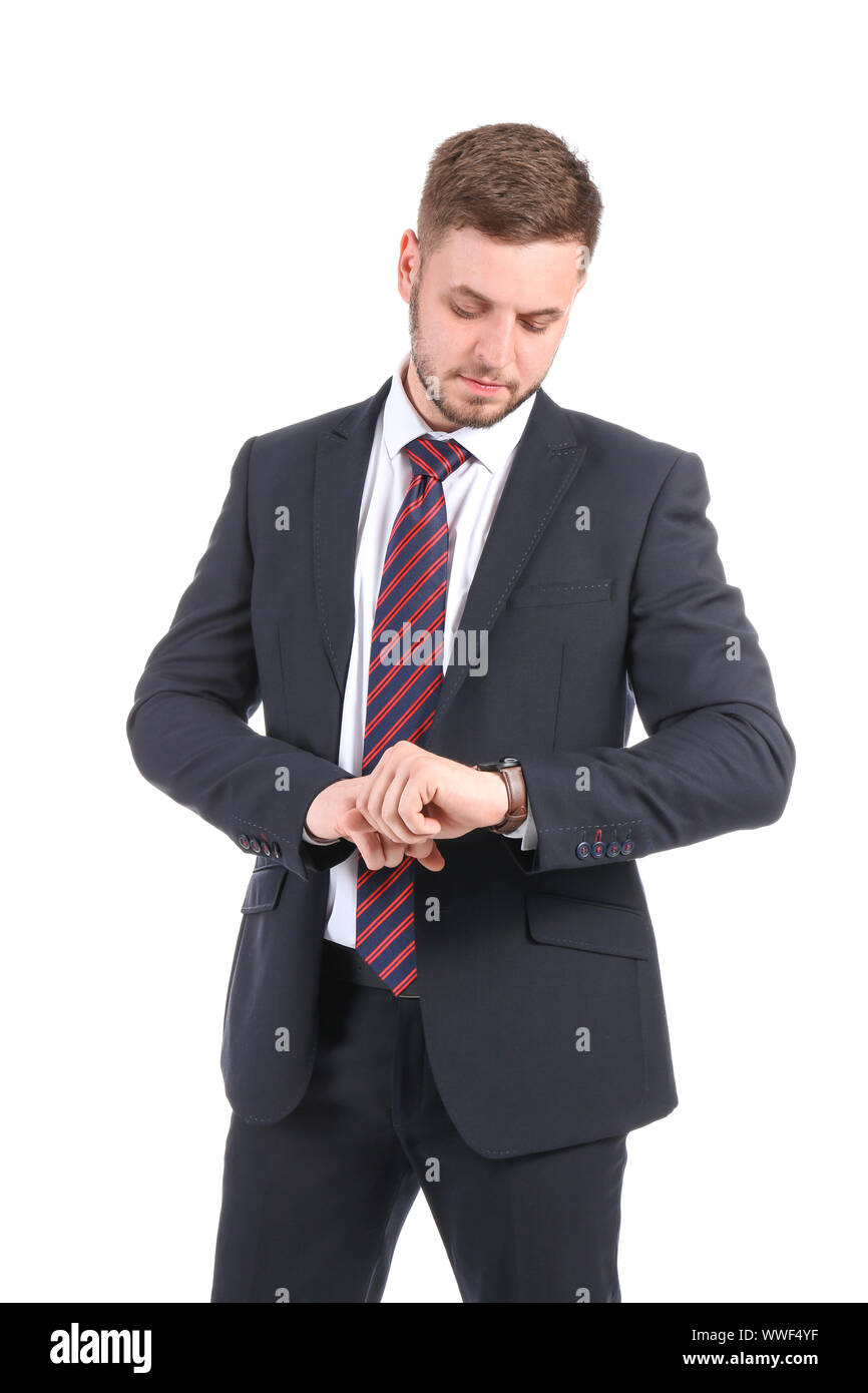 Handsome businessman looking at watch sur fond blanc Banque D'Images