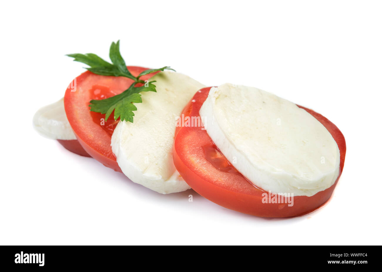 Morceau de mozzarella buffalo avec tomate cerise à fond blanc. Décorées de persil herb. Banque D'Images