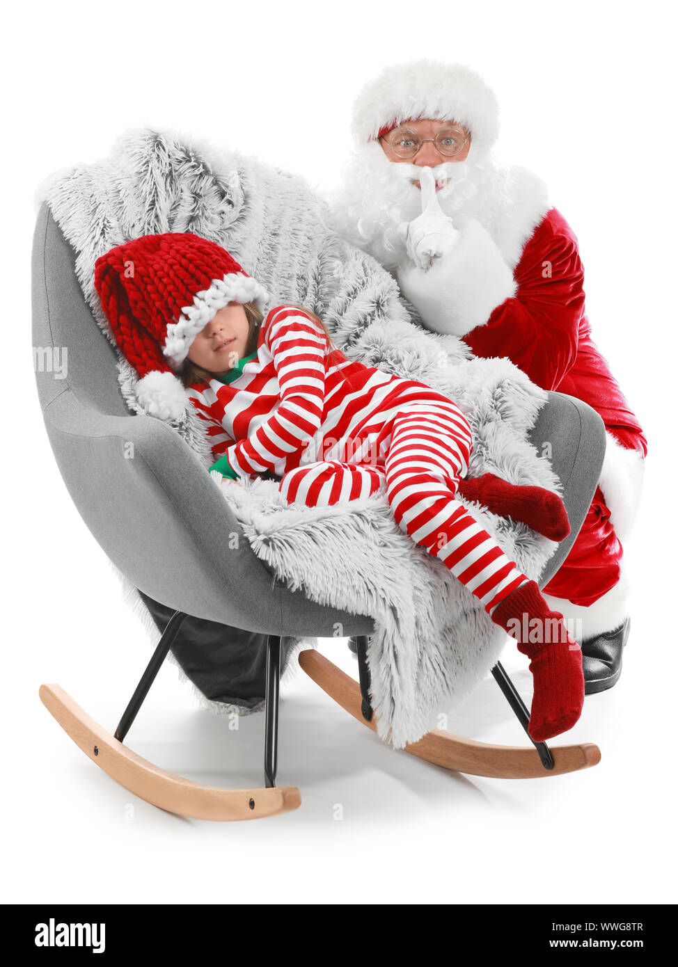 Peu de fille dormir dans un fauteuil et Santa Claus montrant geste silence contre fond blanc Banque D'Images