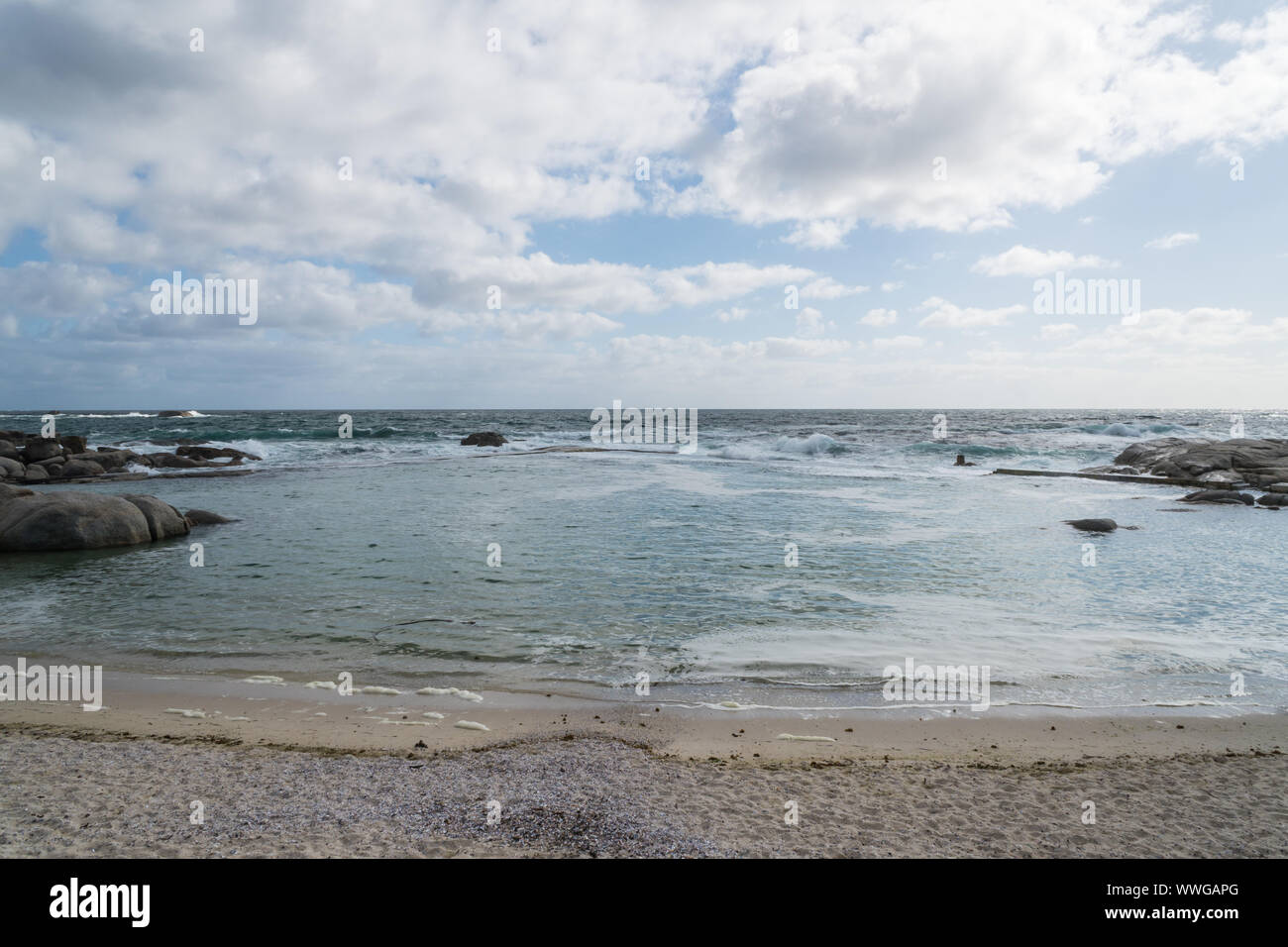 Marée marée côtière ou à une plage de sable blanc sur un ciel nuageux jour de printemps à Camps Bay, Cape Town, Afrique du Sud avec aucun peuple Banque D'Images