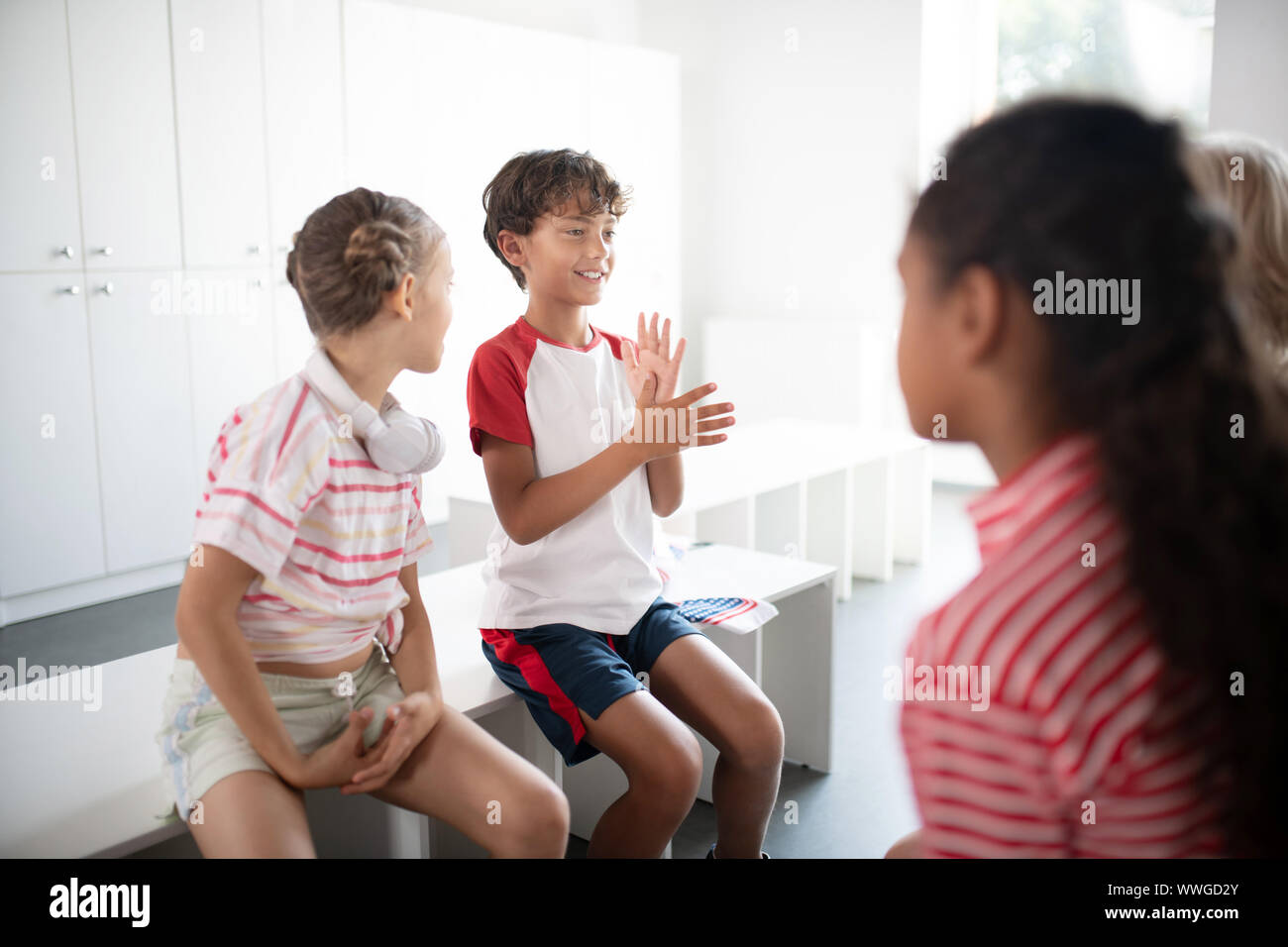 Les garçons et les filles dans les vestiaires avant de communiquer l'entraînement  physique Photo Stock - Alamy