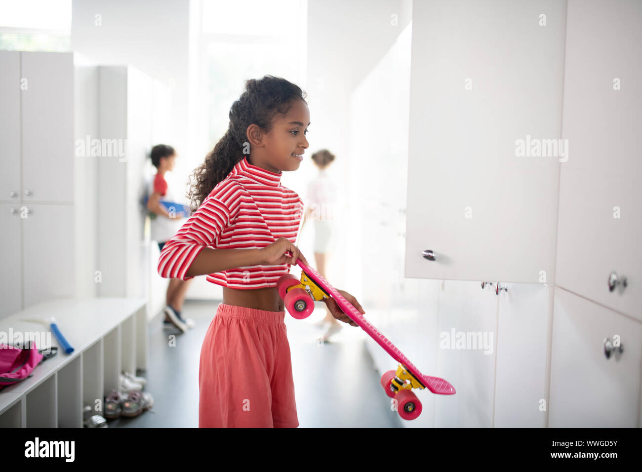 Le port d'écolière chemise rayée mise sou conseil dans le casier Banque D'Images
