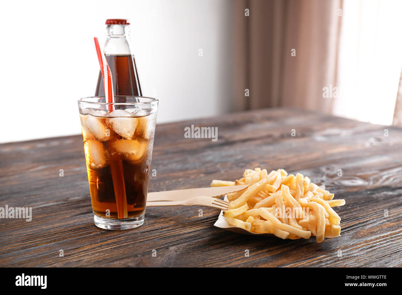 Cold cola et frites savoureuses sur table en bois Banque D'Images