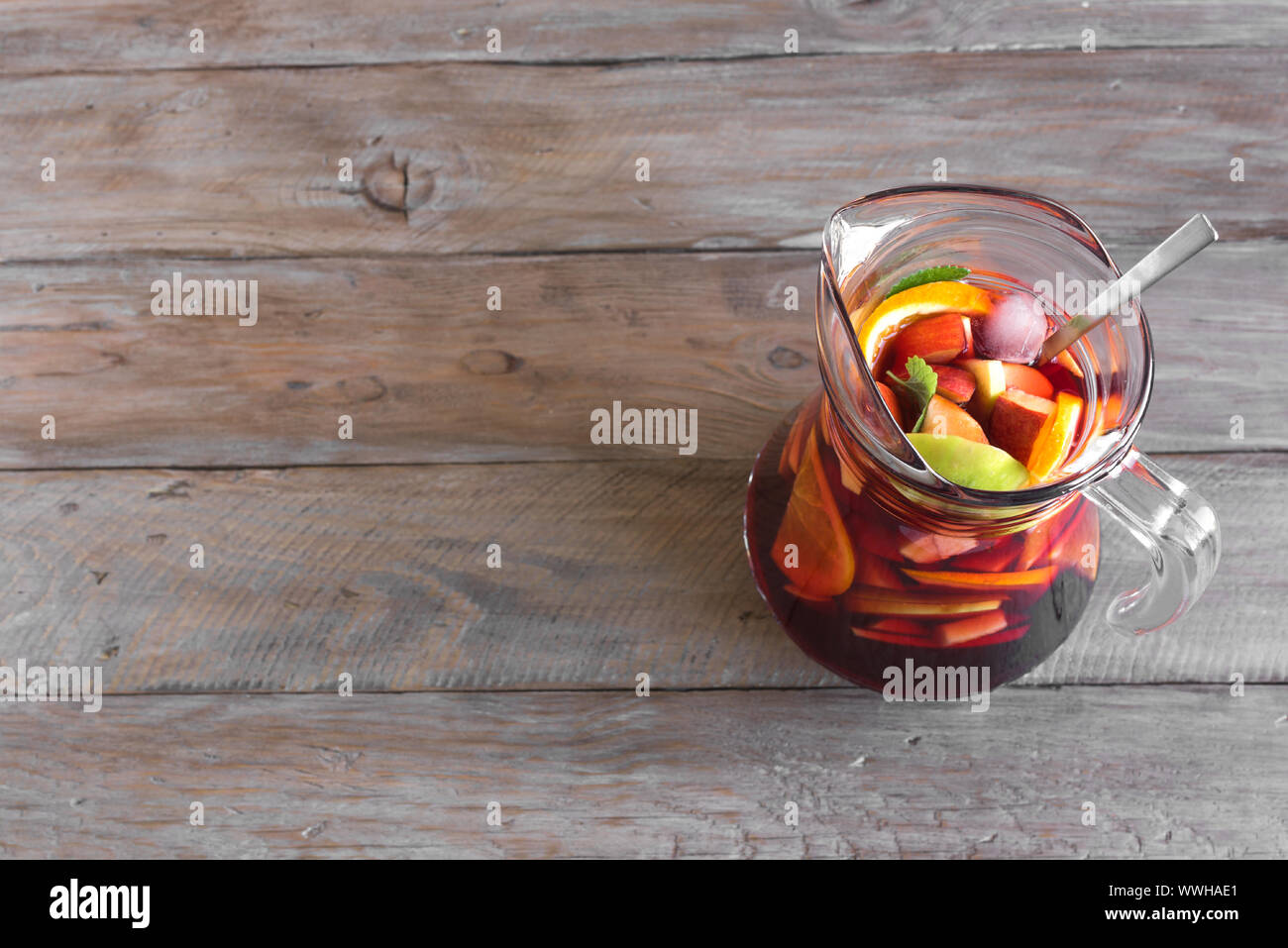 Vin rouge sangria ou punch aux fruits et de la glace de pitcher. Des fruits rafraîchissante sangria sur fond de bois, copie de l'espace. Banque D'Images