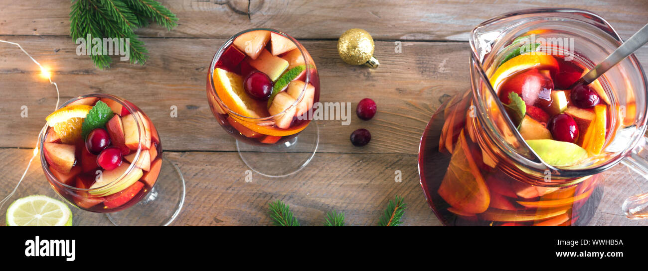 Sangria ou punch de Noël dans les verres et pichet. Vin rouge sangria aux  fruits faits maison et décoration de fête de Noël sur fond de bois, d'un  bandeau Photo Stock -