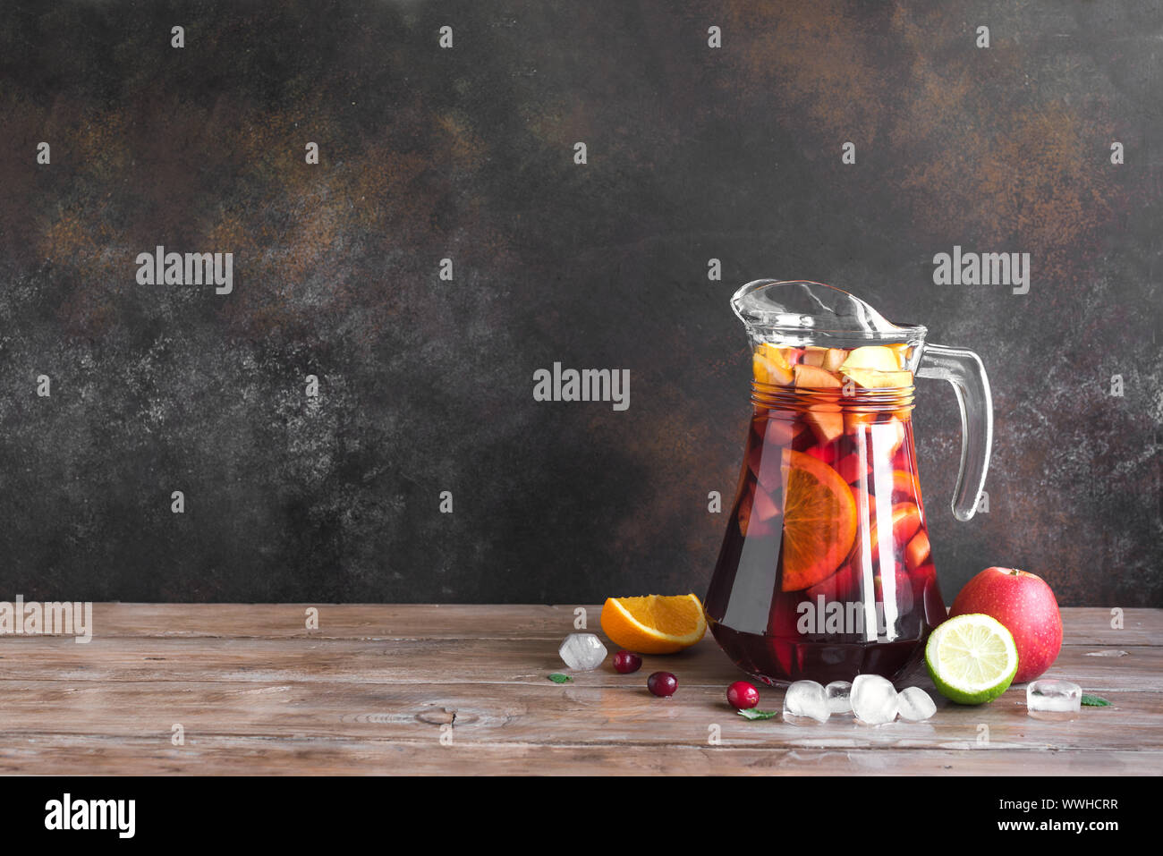 Vin rouge sangria ou punch aux fruits et de la glace de pitcher. Des fruits rafraîchissante sangria sur fond de bois, copie de l'espace. Banque D'Images