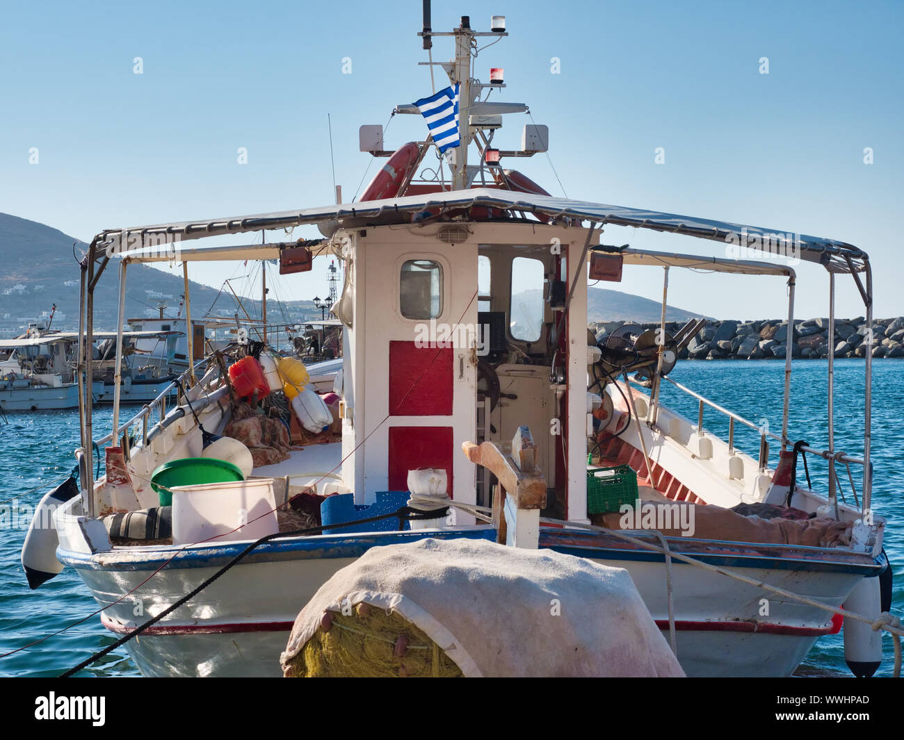 Voilier équipé avec pavillon grec amarré dans le vieux port de Naoussa en Grèce au jour ensoleillé sous ciel bleu Banque D'Images