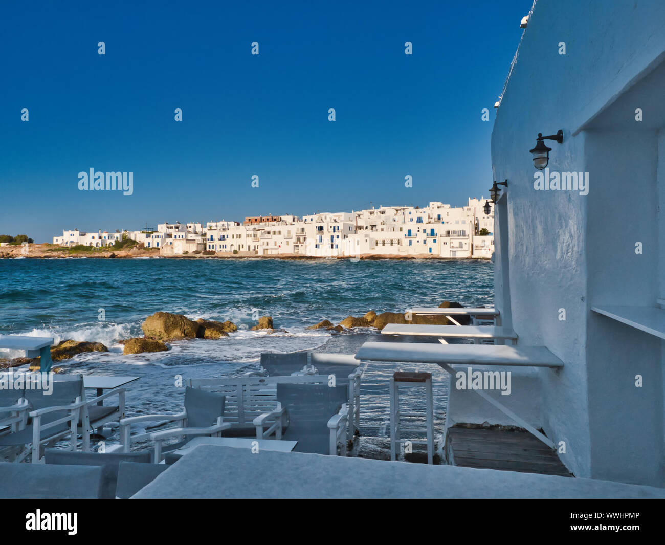 Vue pittoresque de blue sea restaurant vide et maisons sur la côte dans le vieux port de Naoussa Grèce sur sunny day Banque D'Images