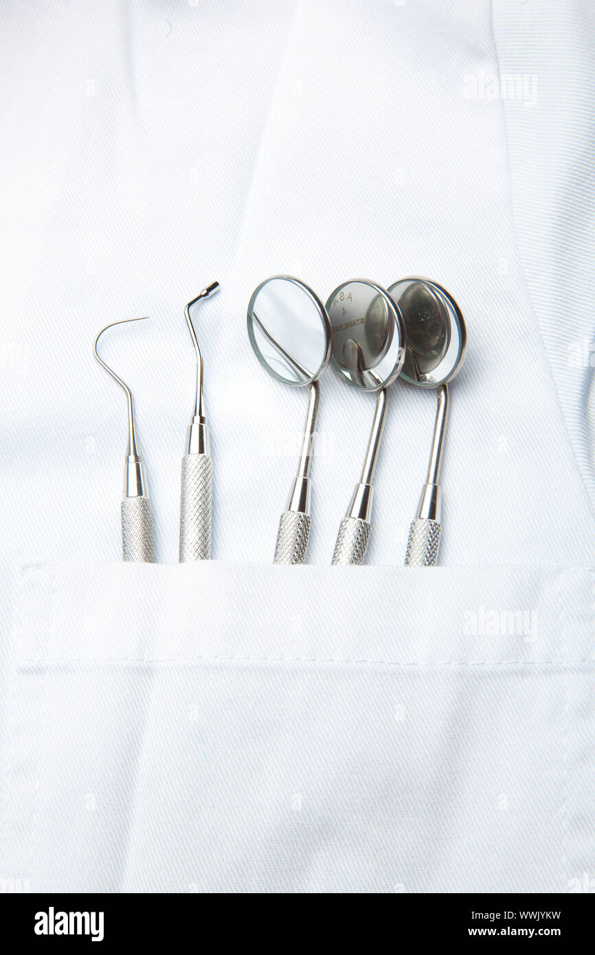 Dentiste blanc avec poche et brosse à dents miroir incliné Banque D'Images