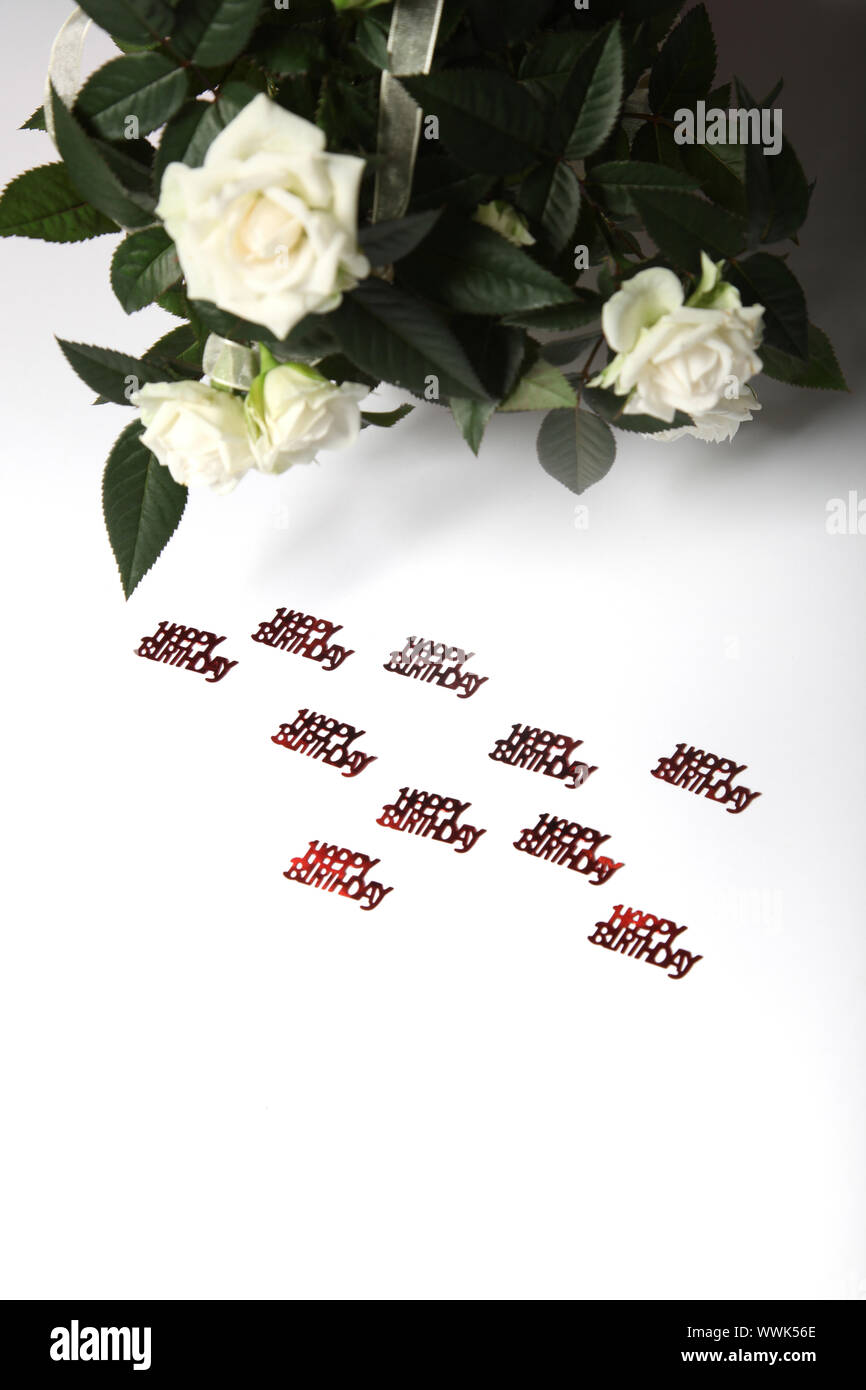 Lettrage en joyeux anniversaire et des roses blanches dans l'arrière-plan, l'espace de texte, format vertical Banque D'Images