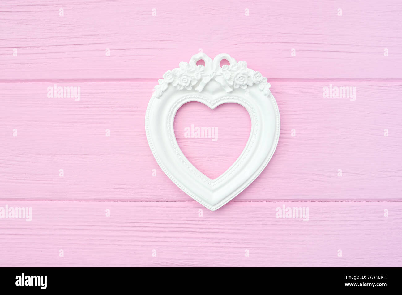 Cadre photo vintage de gypse en forme de cœur sur un fond de bois de rose avec place pour le texte. Parfait pour carte de vœux, invitation, Valentine Banque D'Images