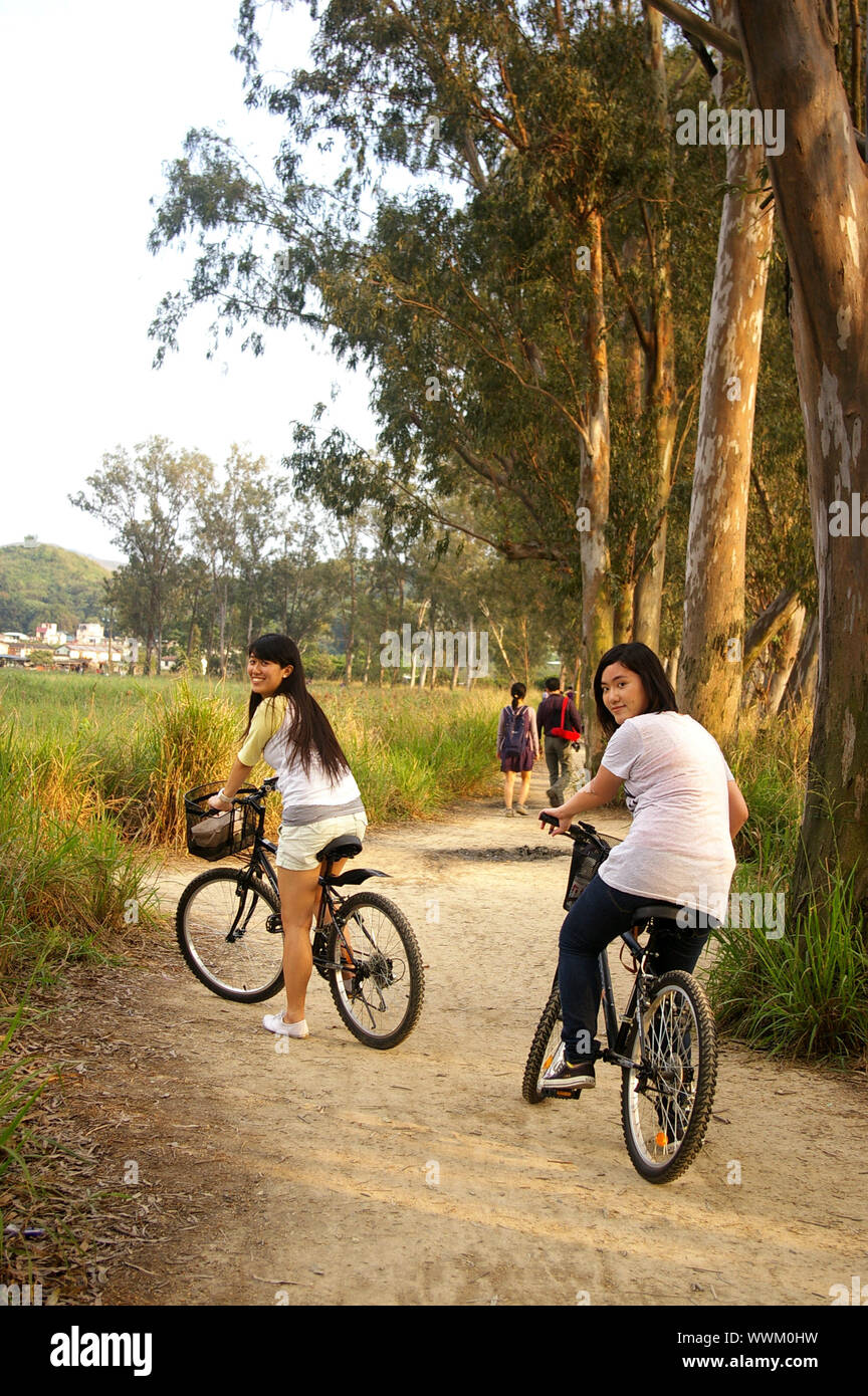 Asian friends riding bicycle Banque D'Images