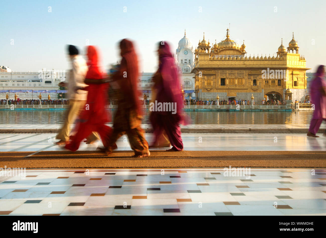 Groupe de pèlerins sikhs marcher par le saint Temple Doré,piscine,l'État du Pendjab, Amritsar, Inde,Asia Banque D'Images