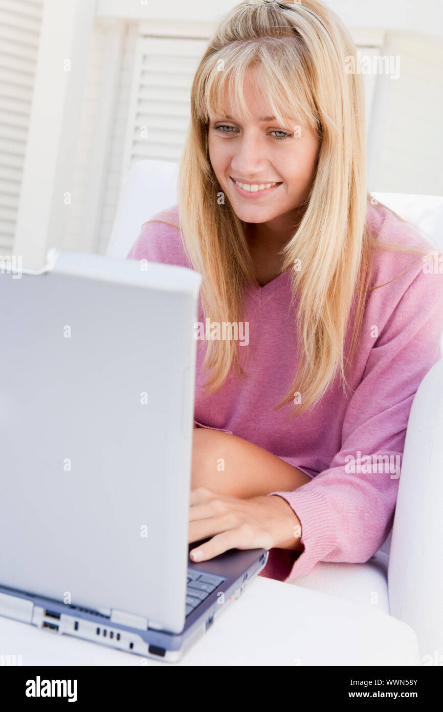 Femme sur patio en utilisant laptop smiling Banque D'Images