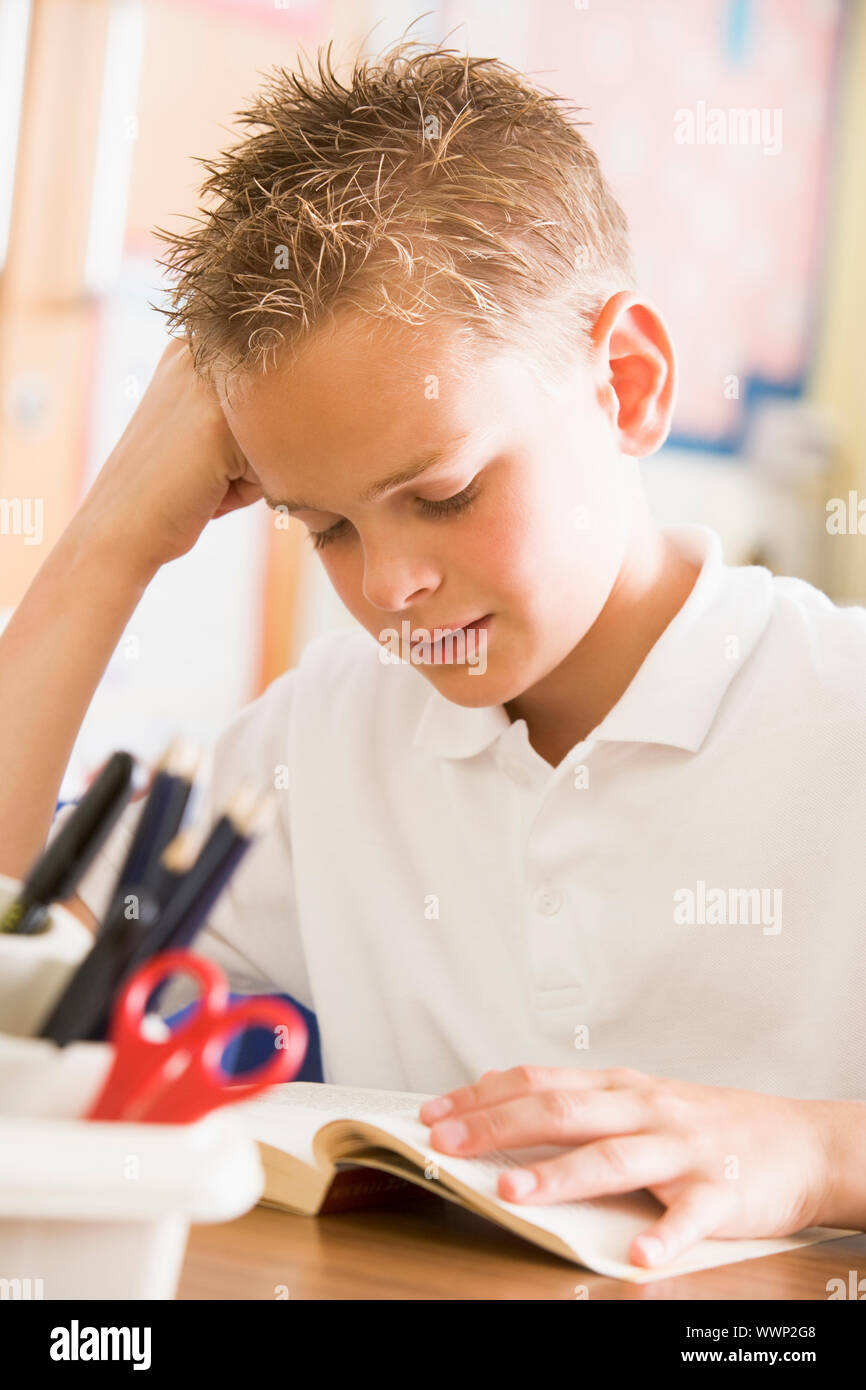 Student in class reading book Banque D'Images