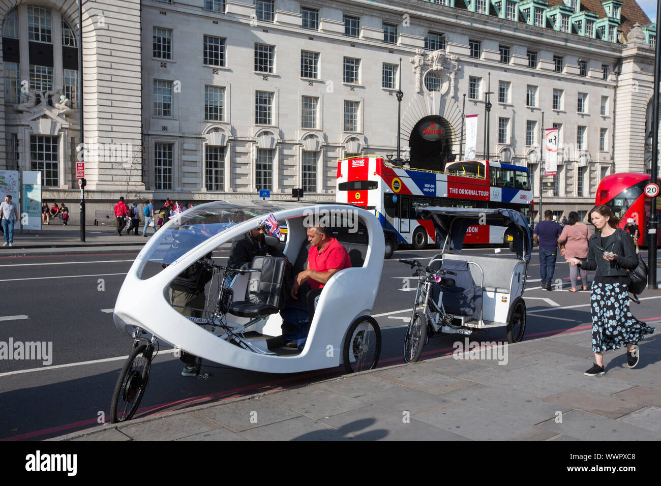 Pousse-pousse électrique des vélos sur le pont de Westminster, Londres, Royaume-Uni. Banque D'Images