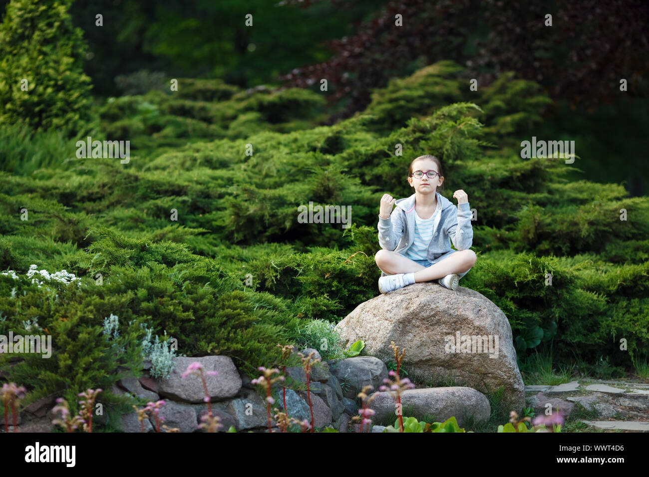 Petite fille méditant dans le parc. Enfant est la pratique du yoga. Mode de vie sain. Focus sélectif. Banque D'Images