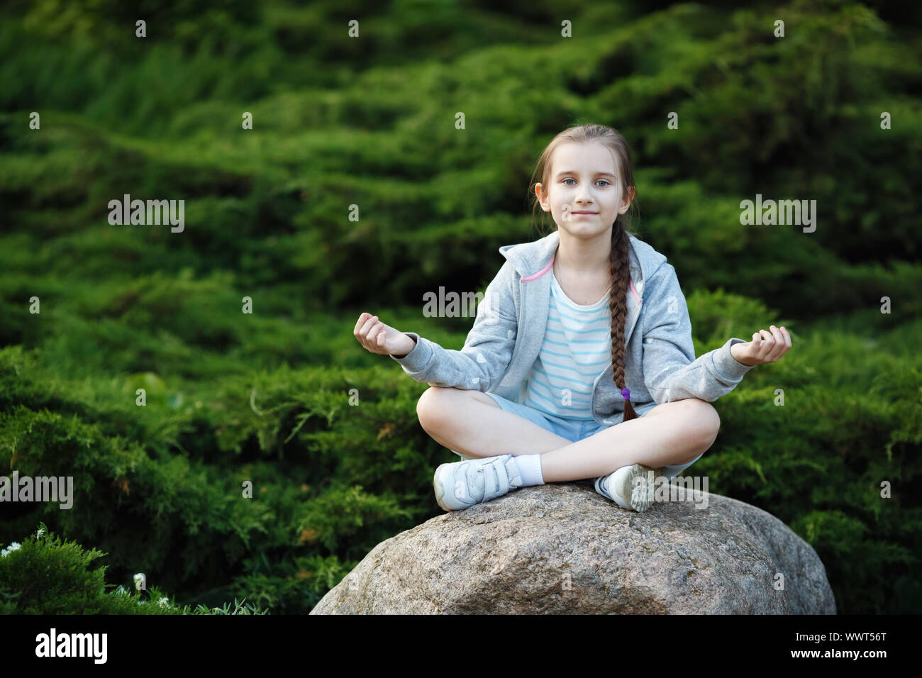 Fille enfant méditant dans le parc. Mode de vie sain. La méditation et le yoga concept. Focus sélectif. Banque D'Images