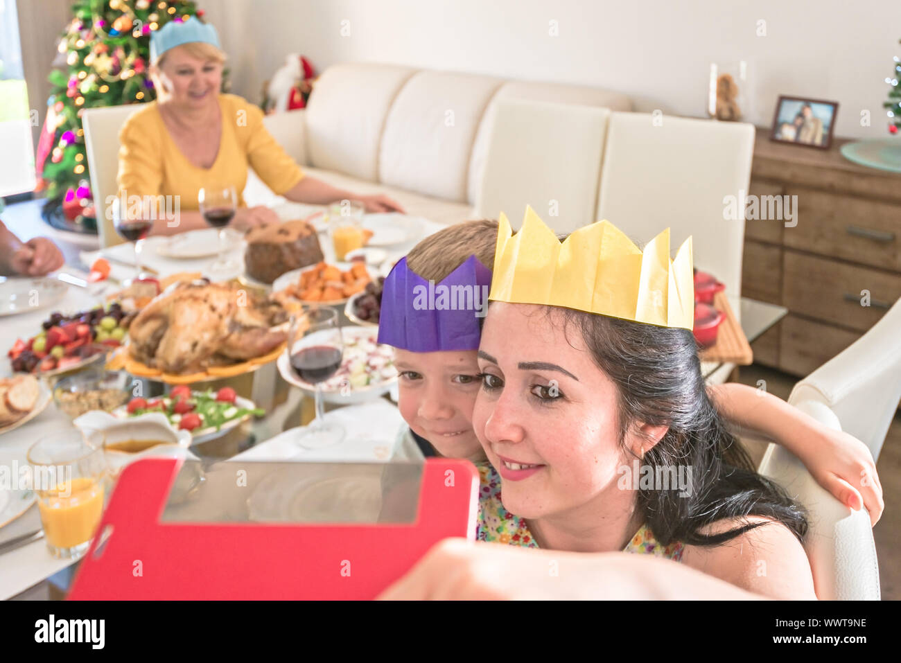 Jeune Australienne mère avec son fils faisant photo selfies en portant des couronnes de papier au cours de la célébration de Noël Banque D'Images