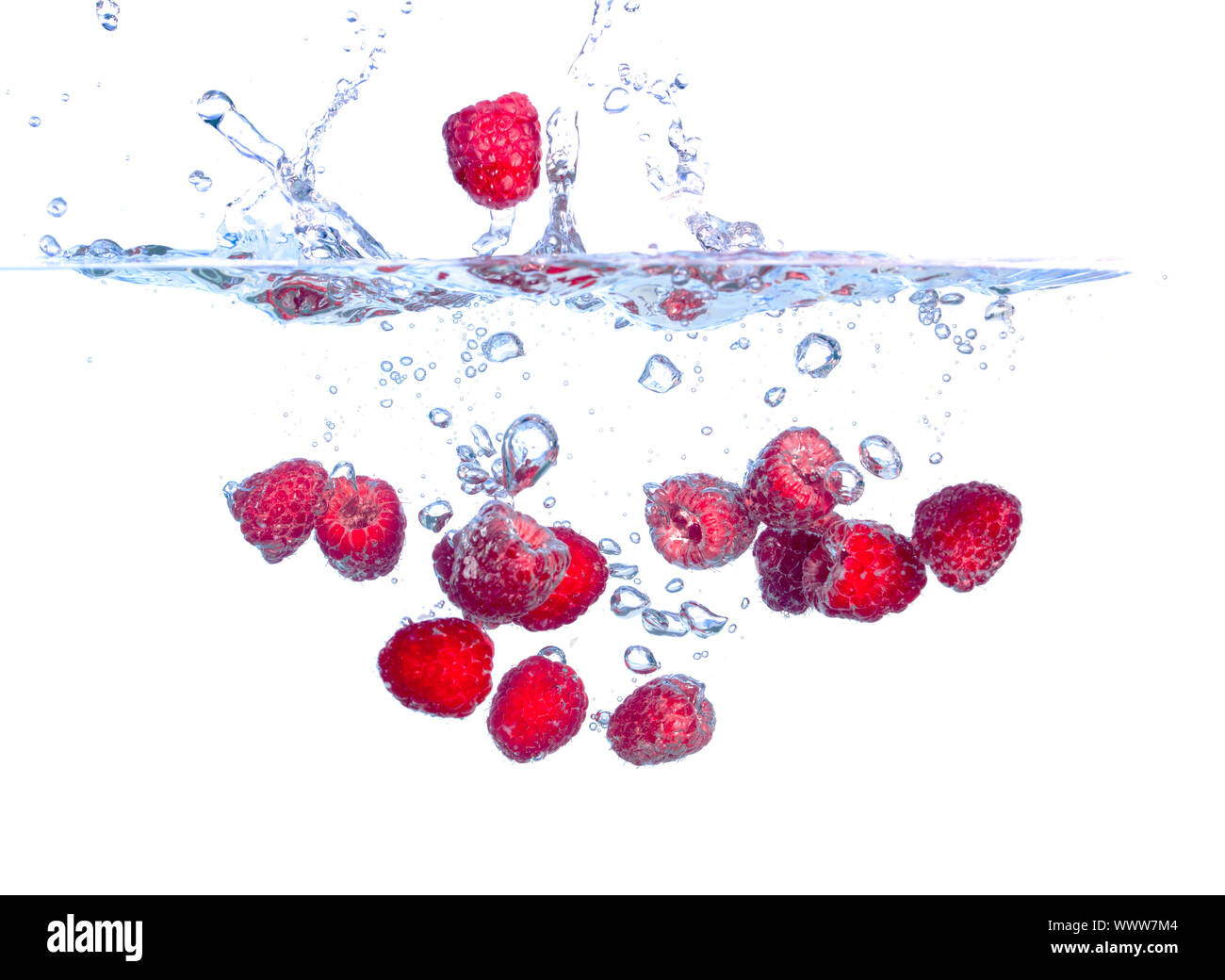 Les framboises rouges tombe sous l'eau avec une éclaboussure, isolé Banque D'Images