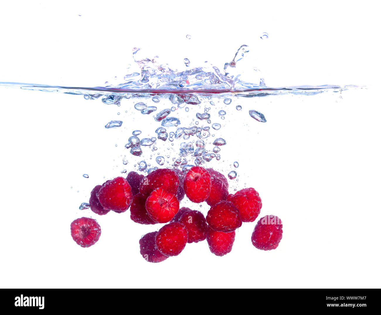 Les framboises rouges tombe sous l'eau avec une éclaboussure Banque D'Images